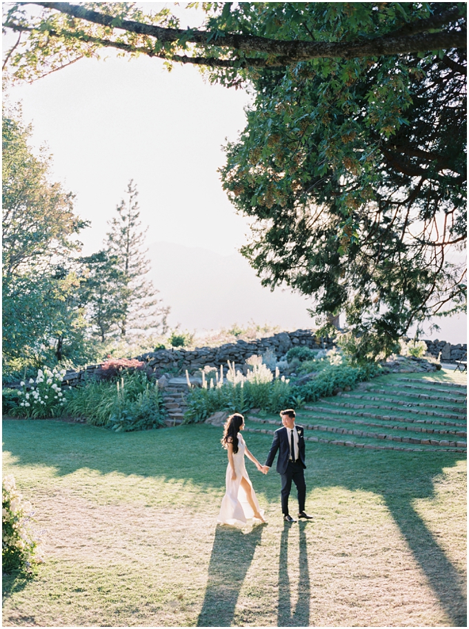 fine art film wedding photo of a bride and groom walking at the griffin house